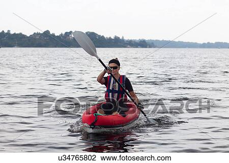 Woman kayaking on still lake View Large Photo Image Stock Image - Woman kayaking on still lake. Fotosearch