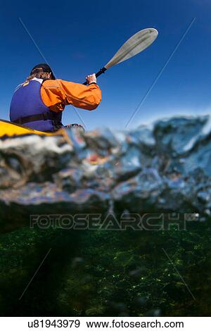 Stock Photo - Woman kayaking viewed from underwater. Fotosearch