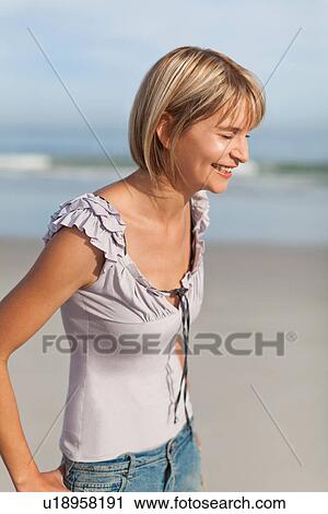 Stock Image - Woman laughing on beach. Fotosearch