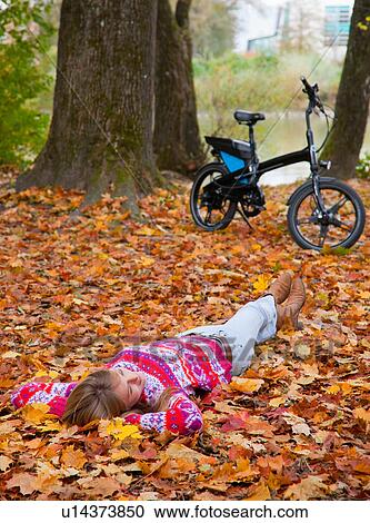 Woman laying in fall leaves View Large Photo Image Stock Image - Woman laying in fall leaves. Fotosearch