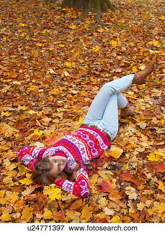 Woman laying in fall leaves View Large Photo Image Stock Photo - Woman laying in fall leaves. Fotosearch