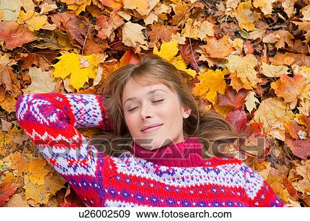 Stock Photo - Woman laying in fall leaves. Fotosearch