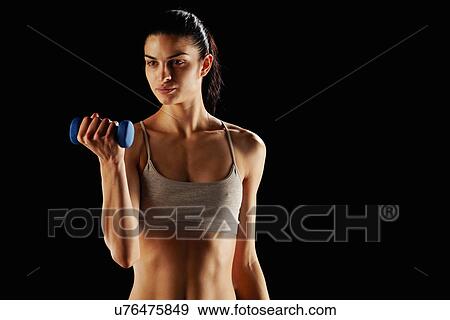 Stock Photo - Woman lifting weights during workout. Fotosearch