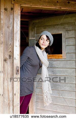 Stock Photography - Woman peering around doorway. Fotosearch