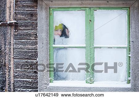 Woman peering out frosty window View Large Photo Image Stock Photo - Woman peering out frosty window. Fotosearch