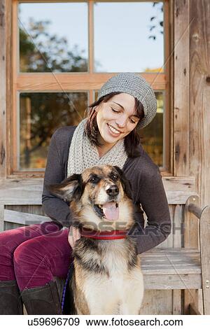 Stock Photo - Woman petting dog on porch. Fotosearch