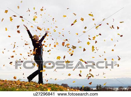 Woman playing in fall leaves View Large Photo Image Stock Image - Woman playing in fall leaves. Fotosearch