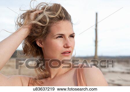 Stock Photo - Woman playing with her hair outdoors. Fotosearch
