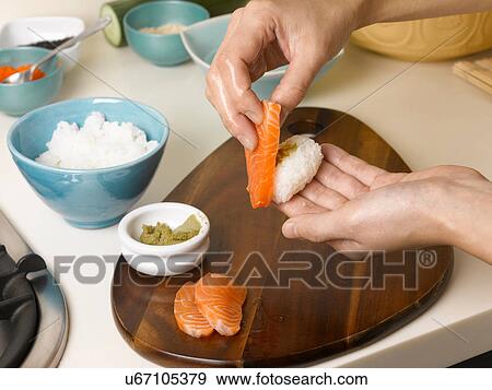 Woman preparing sushi at table View Large Photo Image Stock Photo - Woman preparing sushi at table. Fotosearch