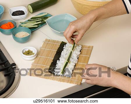 Woman preparing sushi roll at table View Large Photo Image Stock Image - Woman preparing sushi roll at table. Fotosearch