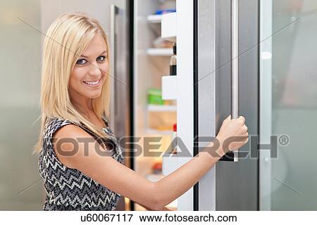 Woman reaching into fridge View Large Photo Image Stock Photo - Woman reaching into fridge. Fotosearch