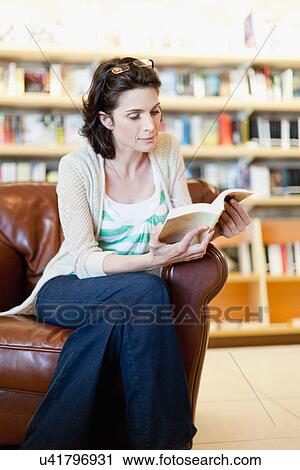 Woman reading book in library View Large Photo Image Stock Image - Woman reading book in library. Fotosearch