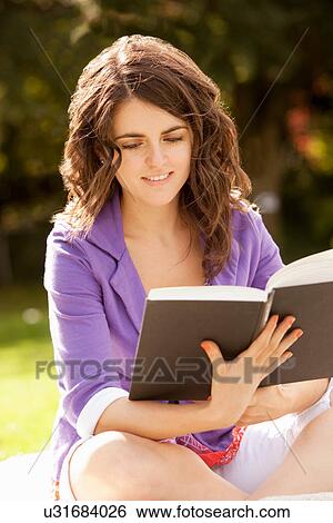 Woman reading book in park View Large Photo Image Stock Photograph - Woman reading book in park. Fotosearch