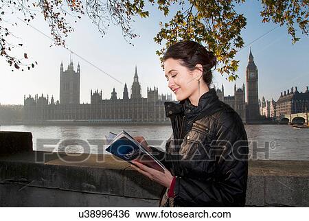 Stock Photograph - Woman reading guidebook of London. Fotosearch