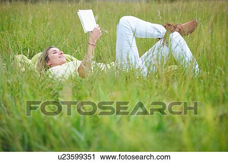Woman reading in tall grass View Large Photo Image Stock Image - Woman reading in tall grass. Fotosearch