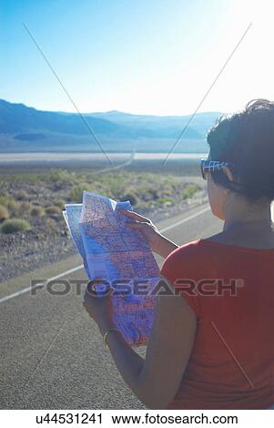 Woman reading map on rural road View Large Photo Image Stock Image - Woman reading map on rural road. Fotosearch