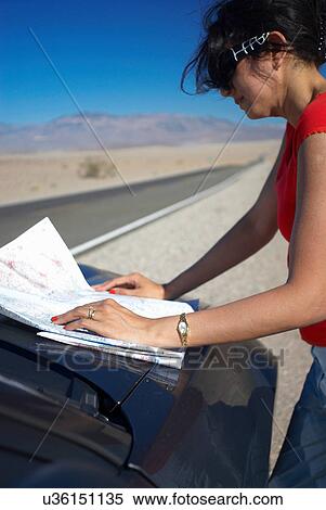 Woman reading map on rural road View Large Photo Image Stock Photography - Woman reading map on rural road. Fotosearch