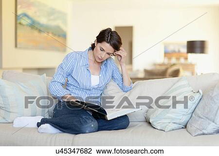 Woman reading on couch View Large Photo Image Stock Image - Woman reading on couch. Fotosearch