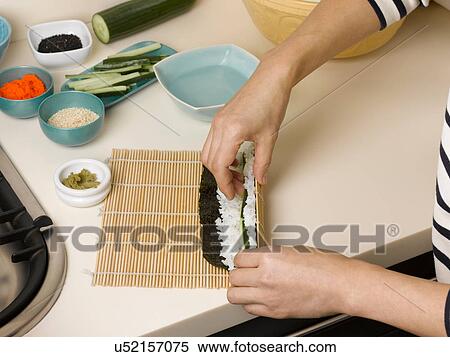 Woman rolling sushi at table View Large Photo Image Stock Photography - Woman rolling sushi at table. Fotosearch