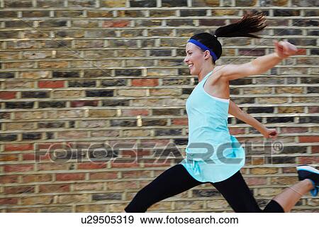 Woman running on city street View Large Photo Image Stock Photo - Woman running on city street. Fotosearch