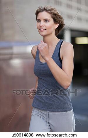 Woman running on city street View Large Photo Image Stock Photo - Woman running on city street. Fotosearch