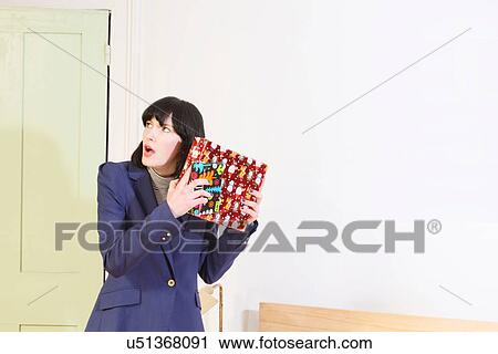 Woman shaking Christmas present View Large Photo Image Stock Image - Woman shaking Christmas present. Fotosearch