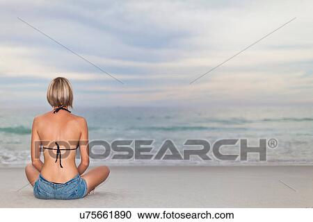 Woman sitting cross legged on beach View Large Photo Image Stock Image - Woman sitting cross legged on beach. Fotosearch