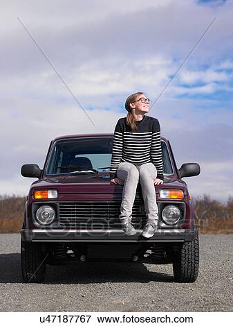 Woman sitting on jeep outdoors View Large Photo Image Stock Photo - Woman sitting on jeep outdoors. Fotosearch