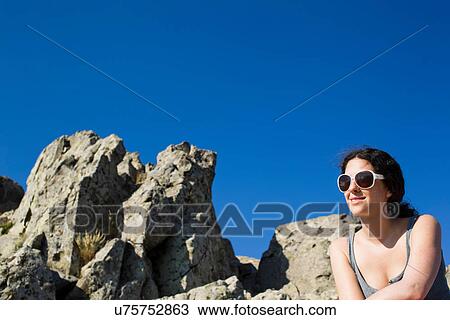 Woman sitting on rocks View Large Photo Image Stock Image - Woman sitting on rocks. Fotosearch