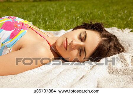 Woman sleeping on blanket in grass View Large Photo Image Picture - Woman sleeping on blanket in grass. Fotosearch