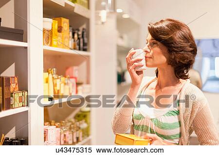 Woman smelling candles in store View Large Photo Image Stock Photography - Woman smelling candles in store. Fotosearch