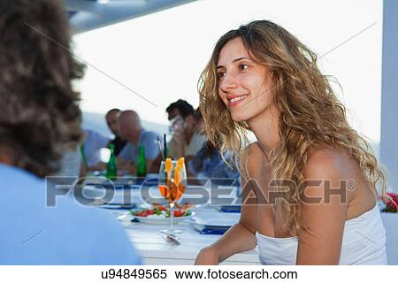 Woman smiling at table with friends View Large Photo Image Stock Photography - Woman smiling at table with friends. Fotosearch