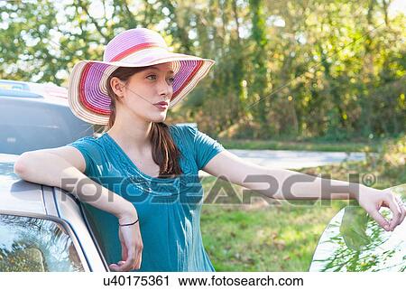 Woman standing by car on road View Large Photo Image Stock Image - Woman standing by car on road. Fotosearch