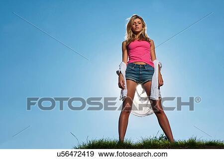 Woman standing on grassy hill View Large Photo Image Stock Photo - Woman standing on grassy hill. Fotosearch