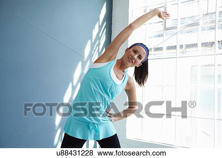 Woman stretching indoors View Large Photo Image Stock Photo - Woman stretching indoors. Fotosearch