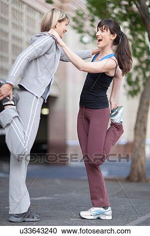 Woman stretching together on city street View Large Photo Image Stock Image - Woman stretching together on city street. Fotosearch