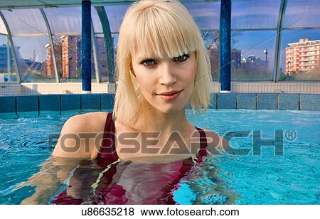 Stock Photo - Woman swimming in indoor pool. Fotosearch