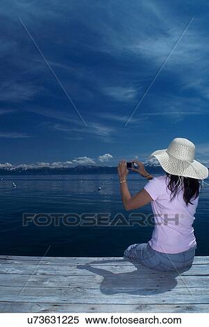 Woman taking pictures of still lake View Large Photo Image Stock Photography - Woman taking pictures of still lake. Fotosearch