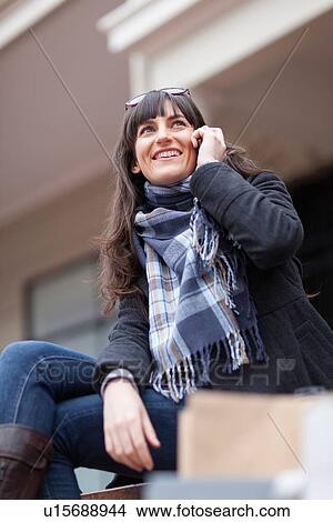 Picture - Woman talking on cell phone outdoors. Fotosearch