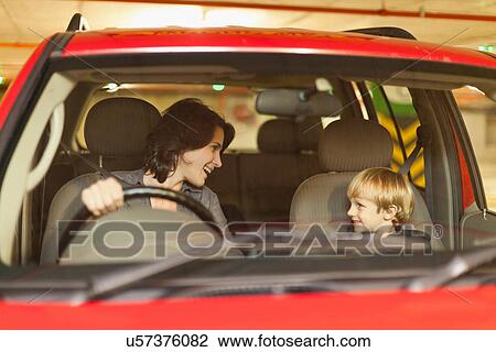 Stock Image - Woman talking to son while driving. Fotosearch