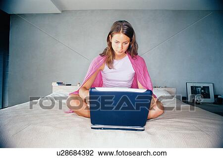 Woman using laptop on bed View Large Photo Image Stock Image - Woman using laptop on bed. Fotosearch