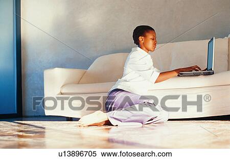 Woman using laptop on couch View Large Photo Image Stock Photography - Woman using laptop on couch. Fotosearch