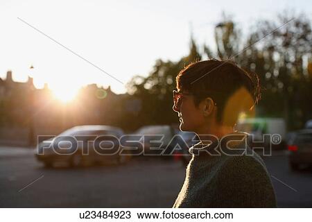 Stock Image - Woman walking on city street. Fotosearch
