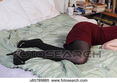 Stock Photography - Woman wearing high heels in bed. Fotosearch