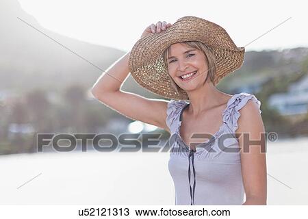 Woman wearing straw hat on beach View Large Photo Image Stock Image - Woman wearing straw hat on beach. Fotosearch