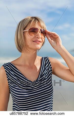 Woman wearing sunglasses outdoors View Large Photo Image Stock Image - Woman wearing sunglasses outdoors. Fotosearch