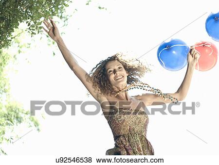 Woman with balloons jumping outdoors View Large Photo Image Stock Photo - Woman with balloons jumping outdoors. Fotosearch