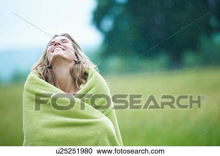 Stock Image - Woman wrapped in blanket outdoors. Fotosearch