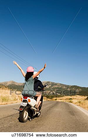Women driving scooter on rural road View Large Photo Image Picture - Women driving scooter on rural road. Fotosearch