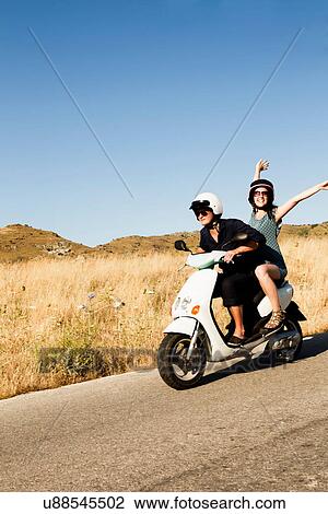 Women driving scooter on rural road View Large Photo Image Stock Image - Women driving scooter on rural road. Fotosearch